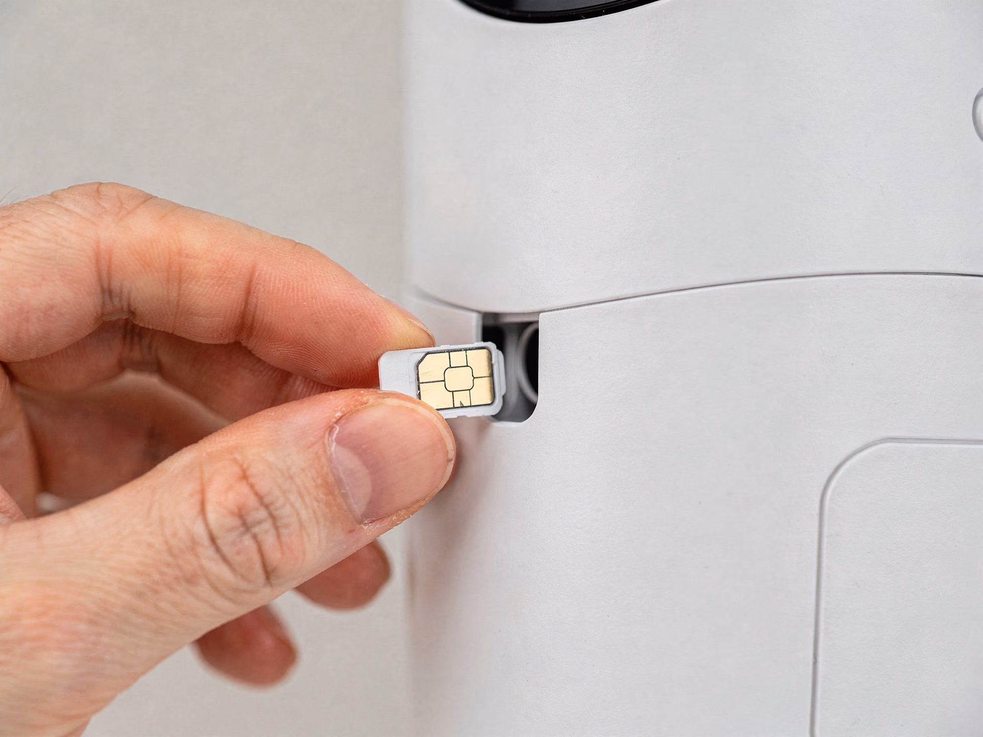 Détail de l'insertion d'une carte SIM nano dans le slot d'une caméra de surveillance
